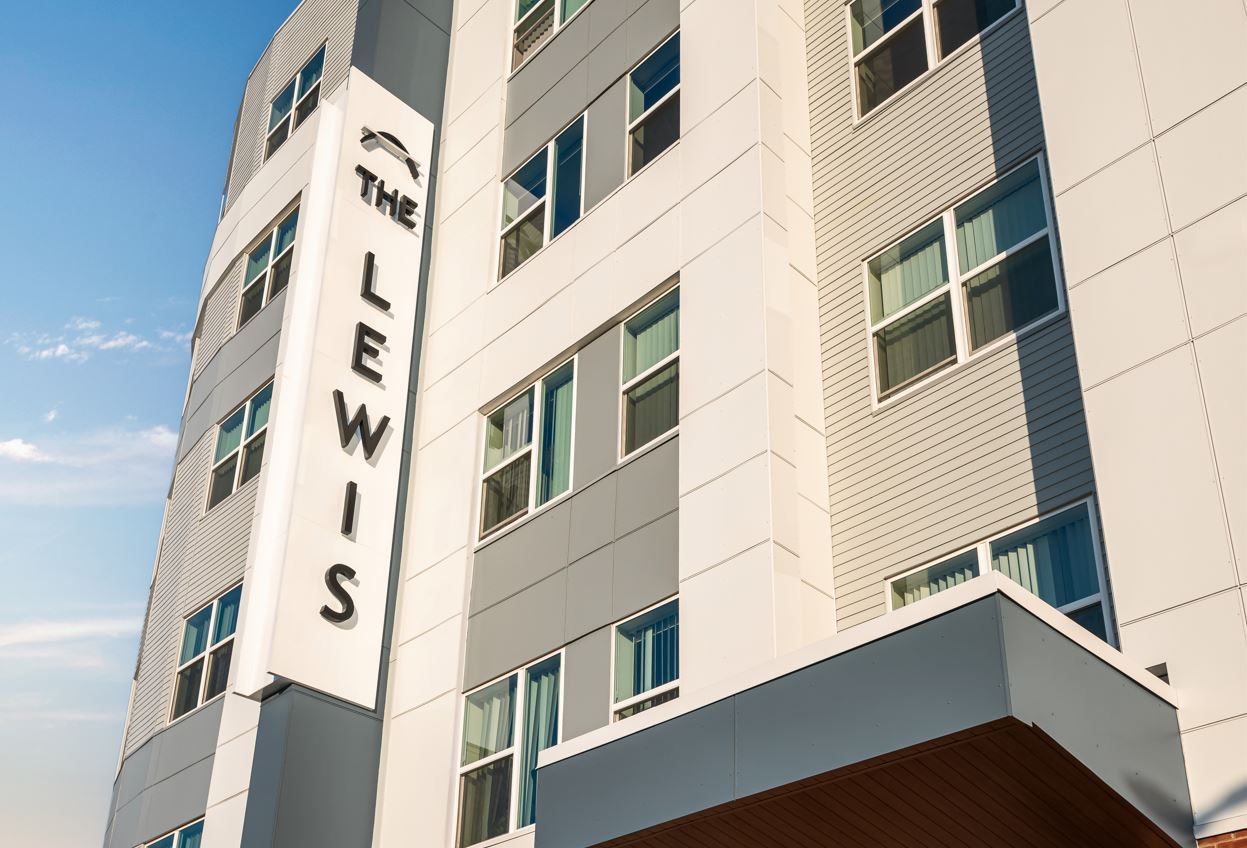Modern building facade with a prominent sign reading "The Lewis."