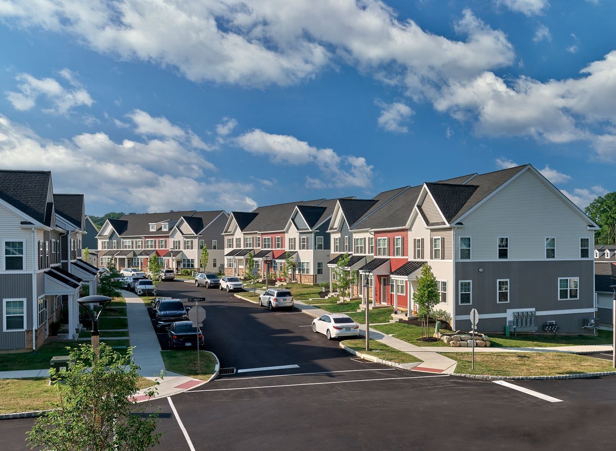 A residential neighborhood with houses, trees, and a blue sky.